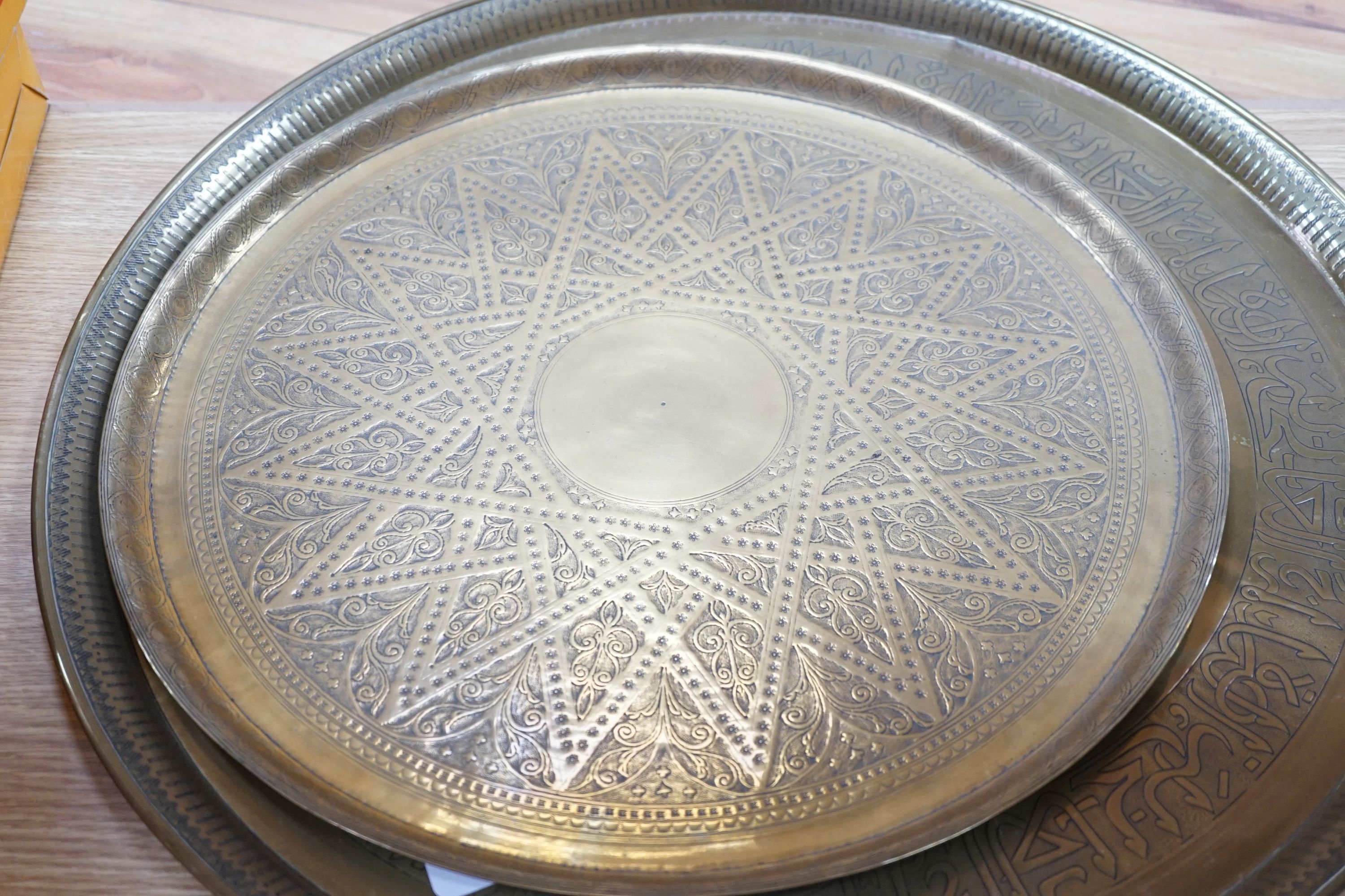 Two 19th century engraved brass circular trays, largest 58cm diameter